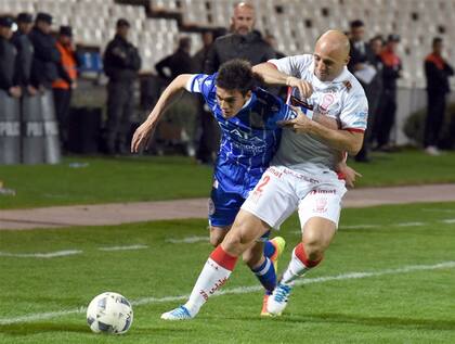 Mancinelli, con esfuerzo, frena un avance de Garro, delantero de Godoy Cruz