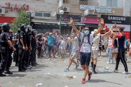 Manifestantes ante varios policías tunecinos durante una protesta en Túnez, capital de Túnez, el domingo 25 de julio de 2021