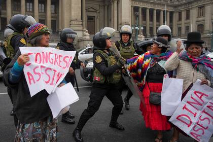 Manifestantes antigubernamentales intentan pasar a través de la policía que los bloquea afuera del Palacio de Justicia mientras intentan llegar al Congreso, donde la presidenta peruana Dina Boluarte daba su segundo discurso sobre el Estado de la Nación en el Día de la Independencia en Lima, Perú, el domingo 28 de julio de 2024. (AP Foto/Guadalupe Pardo)