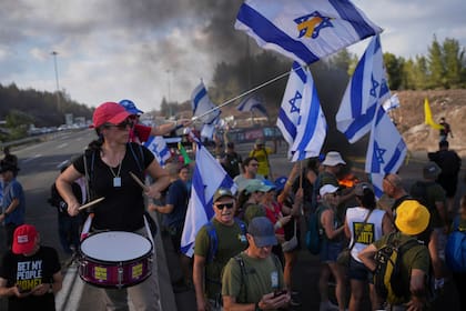 Manifestantes bloquean un camino durante una protesta para exigir la liberación de los rehenes cautivos de Gaza y pedir al gobierno de Israel que dé marcha atrás a su decisión de capturar Ciudad de Gaza y otras zonas de la Franja de Gaza, el domingo 17 de agosto de 2025, cerca de Jerusalén