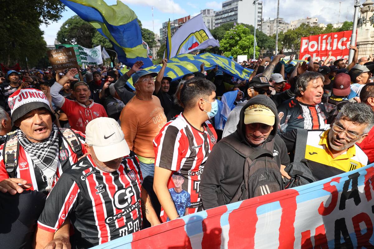 Manifestantes caracterizados con banderas, camisetas y colores de clubes de Primera y el Ascenso durante la marcha del miércoles, antes de los incidentes en las adyacencias del Congreso