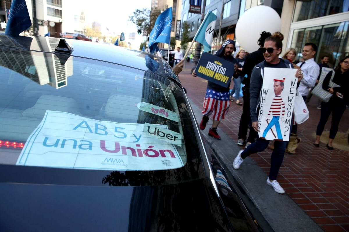 Manifestantes celebran la ley de California que reconoce a los conductores de las aplicaciones móviles como empleados en lugar de contratados