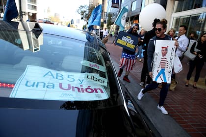 Manifestantes celebran la ley de California que reconoce a los conductores de las aplicaciones móviles como empleados en lugar de contratados