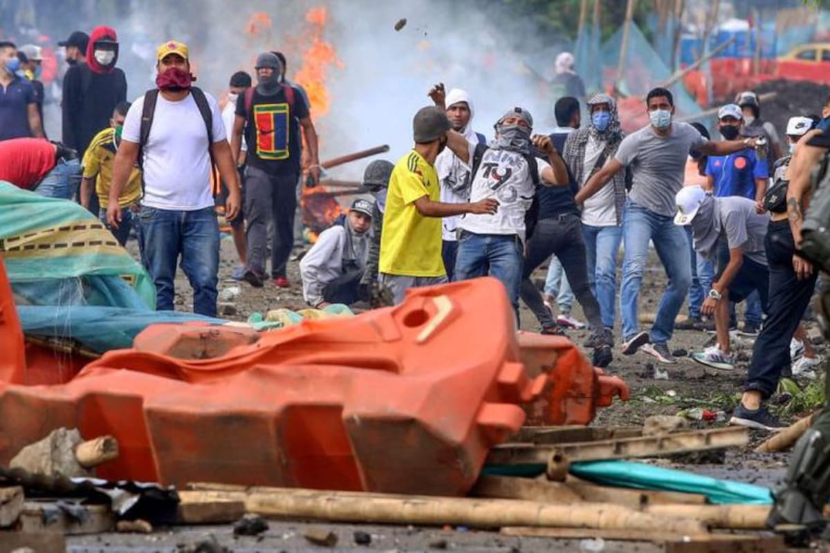 Manifestantes chocan con la policía antidisturbios durante una protesta contra un proyecto de reforma tributaria lanzado por el presidente colombiano Iván Duque, en Cali, Colombia