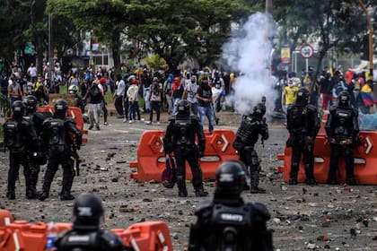 Manifestantes chocan con la policía antidisturbios durante una protesta contra un proyecto de reforma tributaria lanzado por el presidente colombiano Iván Duque, en Cali