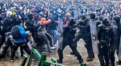 Manifestantes chocan con la policía antidisturbios durante una protesta contra un proyecto de reforma tributaria lanzado por el presidente colombiano Iván Duque, en Bogotá, Colombia (AFP/ Juan Barreto)