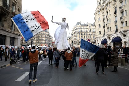 Manifestantes con banderas francesas llegan a una manifestación, el martes 7 de marzo de 2023 en París