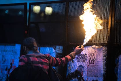 Manifestantes con fuego delante de las vallas