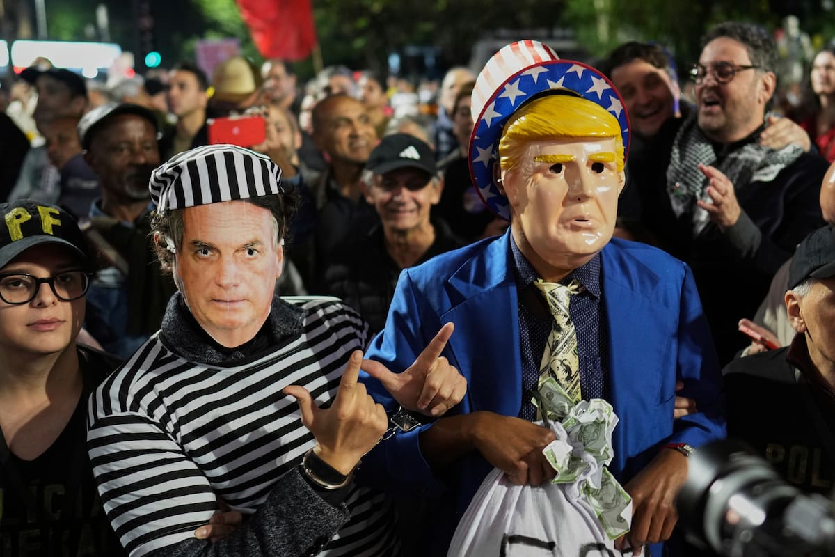 Manifestantes con máscaras de Trump y de Bolsonaro protestan después de que Trump anunciara aranceles del 50% a bienes brasileños, en San Pablo