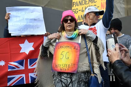 Manifestantes contra el bloqueo llevan pancartas en los escalones del parlamento estatal de Victoria en Melbourne el 10 de mayo, en plena pandemia de coronavirus