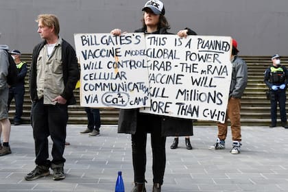 Manifestantes contra el bloqueo llevan pancartas en los escalones del parlamento estatal de Victoria en Melbourne el 10 de mayo, en plena pandemia de coronavirus