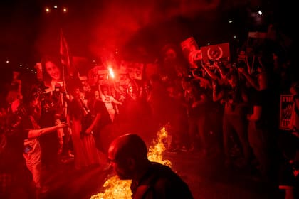 Manifestantes encienden un fuego durante una protesta contra el gobierno del primer ministro israelí, Benjamin Netanyahu, y piden la liberación de los rehenes retenidos en la Franja de Gaza por Hamáas y otros grupos armados, en Tel Aviv, Israel, el domino 26 de mayo de 2024.
