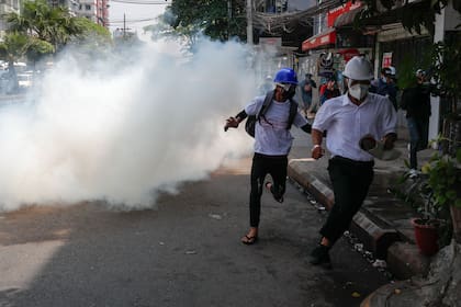 Manifestantes escapan de los gases lacrimógenos en Rangún