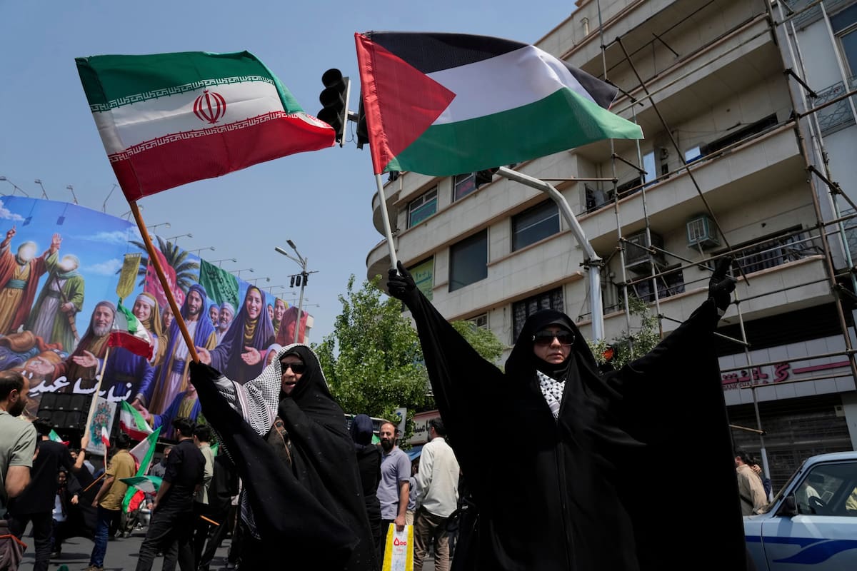 Manifestantes iraníes ondean banderas de Irán y Palestina en una concentración contra Israel en Teherán