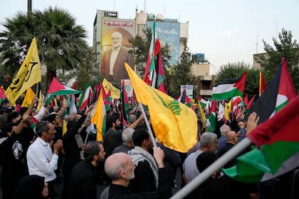 Manifestantes iraníes ondean banderas iraníes, palestinas y del grupo libanés Hezbollah en una manifestación para condenar el asesinato del líder de Hamás Ismail Haniyeh, en Teherán (Archivo)