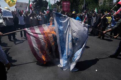 Manifestantes iraníes queman banderas de Israel y Estados Unidos en Teherán el 20 de junio del 2025