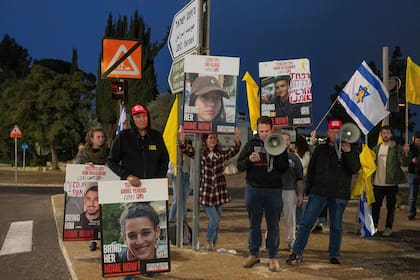Manifestantes israelíes fuera de la oficina del primer ministro Benjamin Netanyahu con fotografías de Liri Albag y otros rehenes durante una protesta para exigir su liberación de manos del grupo miliciano Hamás, el domingo 5 de enero de 2025, en Jerusalén. (AP Foto/Ohad Zwigenberg)