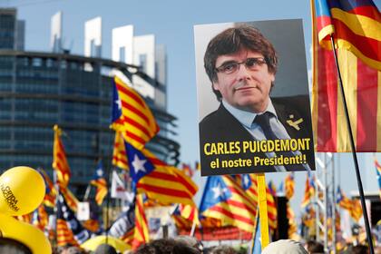 Manifestantes levantan un cartel del expresidente regional catalán Carles Puigdemont afuera del Parlamento Europeo en Estrasburgo, Francia. (AP Foto/Jean-Francois Badias)