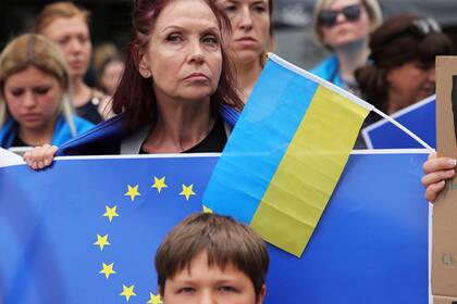 Manifestantes llevan banderas de Ucrania y la Union Europea  en una concentración en favor de Ucrania en las afueras de la UE en Bruselas el 23 de junio del 2022. (AP Foto/Olivier Matthys)