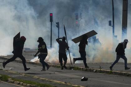 Manifestantes marchan con escudos improvisados ​​durante las protestas contra las políticas económicas del presidente Guillermo Lasso en el centro de Quito, Ecuador, el viernes 24 de junio de 2022. (AP Foto/Dolores Ochoa)