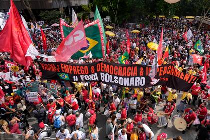 Manifestantes marchan durante una protesta contra el presidente brasileño Jair Bolsonaro y hacen un llamado a su juicio político por la manera en que el mandatario manejó la pandemia del coronavirus, en Sao Paulo, Brasil, el sábado 2 de octubre de 2021. (AP Foto/Andre Penner)