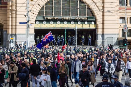 Manifestantes marchan en un mitin del Día de la Libertad frente a la estación de Flinders Street en Melbourne contra las restricciones