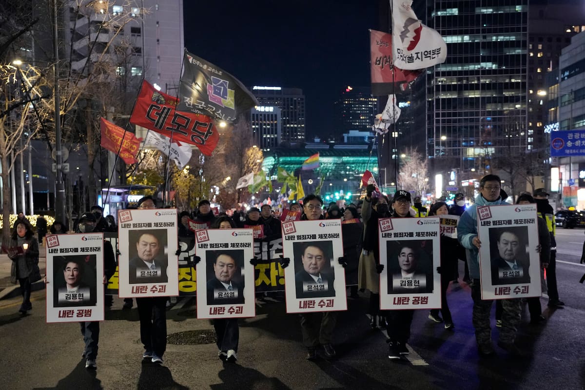 Manifestantes marchan hacia la oficina presidencial tras una vigilia con velas en repudio al presidente Yoon Suk-yeol, en Seúl