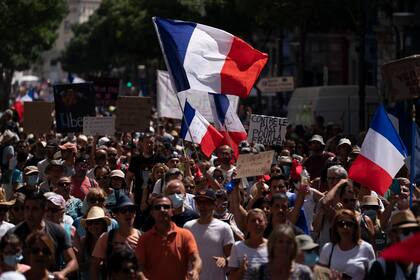 Manifestantes marchan por Marsella, Francia, sábado 14 de agosto de 2021, contra el pasaporte COVID-19, una certificación obligatoria para entrar a restaurantes, trenes de alta velocidad y otros recintos. (AP Foto/Daniel Cole)