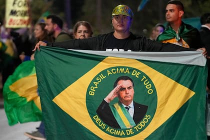 Manifestantes muestran su apoyo al expresidente de Brasil, Jair Bolsonaro, a la entrada del complejo donde vive, para denunciar la orden de arresto domiciliario emitida por el Supremo Tribunal Alexandre contra él, en Brasilia, Brasil, el 5 de agosto de 2025.