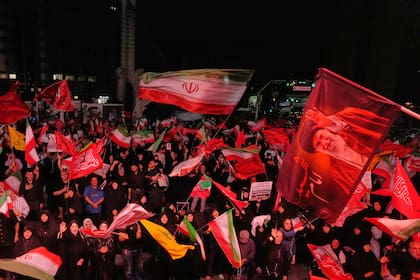Manifestantes ondean banderas iraníes en una concentración en conmemoración del ayatollah Alí Khamenei, el sábado 11 de julio