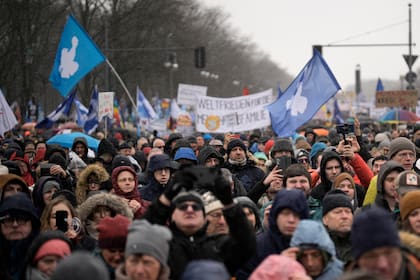 Manifestantes participan en una protesta para condenar el suministro de armas de Alemania a Ucrania y exigir un diálogo de paz para poner fin a la guerra, en Berlín, el sábado 25 de febrero de 2023. (AP Foto/Markus Schreiber)