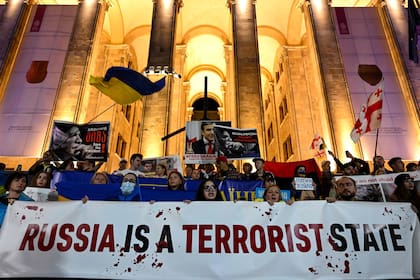 Manifestantes protestan contra los ataques rusos a Ucrania durante una manifestación organizada por refugiados y activistas ucranianos, en Tiflis el 10 de octubre de 2022.