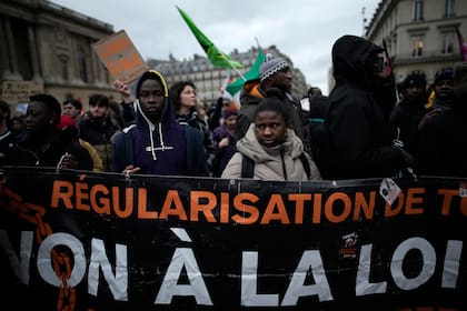 Manifestantes protestan contra una polémica propuesta de ley migratoria afuera de la sede del Consejo Constitucional de Francia, en enero de 2024