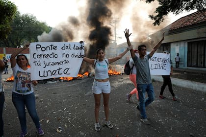 Manifestantes claman en un cartel a los miembros de la Guardia Nacional que detengan la represión y se unan a sus filas (Archivo)