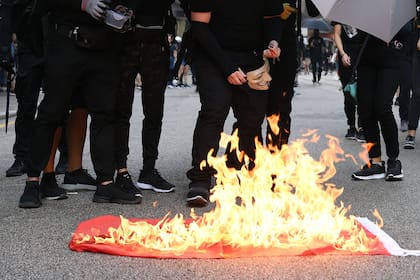 Manifestantes queman la bandera china, símbolo de la revolución