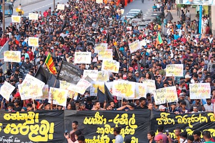 Manifestantes reaccionan después de que la policía les lance una lata de gas lacrimógeno en Colombo, Sri Lanka, el sábado 9 de julio de 2022. (AP Foto/Amitha Thennakoon)