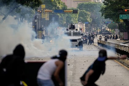 Manifestantes se enfrentan con la policía durante protestas contra los resultados oficiales que declaran la reelección del presidente Nicolás Maduro, un día después de los comicios, en Caracas, Venezuela, el 29 de julio de 2024. (AP/Matias Delacroix, File)
