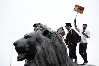 Manifestantes sostienen carteles mientras participan en una protesta contra Trump en Trafalgar Square, Londres