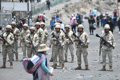 MAnifestantes y efectivos de seguridad en el puente Añashuayco, cerca del aeropuerto de Arequipa. (Diego Ramos / AFP)