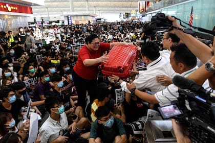 Manifestantes y pasajeros se mezclaron ayer en el tumulto de la toma del aeropuerto de Hong Kong