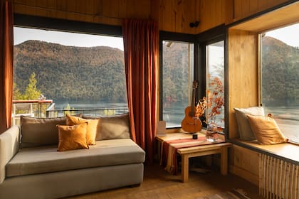 Mantas enrolladas en canastos en los rincones para protegerse del frio cuando se está en el deck, alfombras tejidas, géneros de color en almohadones y cortinas decoran con gusto.
