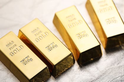 Many gold bars on silver background, closeup. Lingotes de Oro