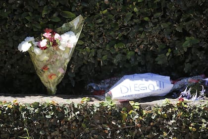 Seis ramos y un cartel de agradecimiento a Maradona, la pequeña ofrenda en la puerta del cementerio de Bella Vista.