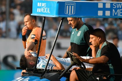 Maravilla Martínez en el momento que es sacado del campo en una camilla. El delantero de Racing pisó mal y se torció el tobillo izquierdo
