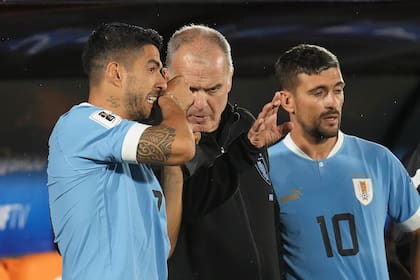 Marcelo Bielsa da indicaciones a Luis Suárez antes de que el goleador ingrese en el 3-0 de Uruguay sobre Bolivia, ante Giorgian De Arrascaeta; el DT argentino ya dio forma a un equipo muy reconocible como de él.