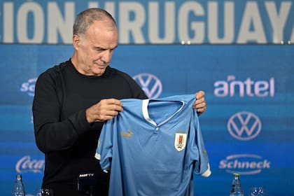 Marcelo Bielsa y la camiseta uruguaya, en el momento de su presentación como entrenador de la selección charrúa, en el estadio Centenario