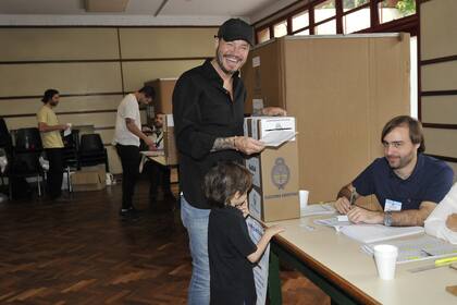 Marcelo Tinelli, depositando su voto en la urna, junto a su hijo menor, Lorenzo