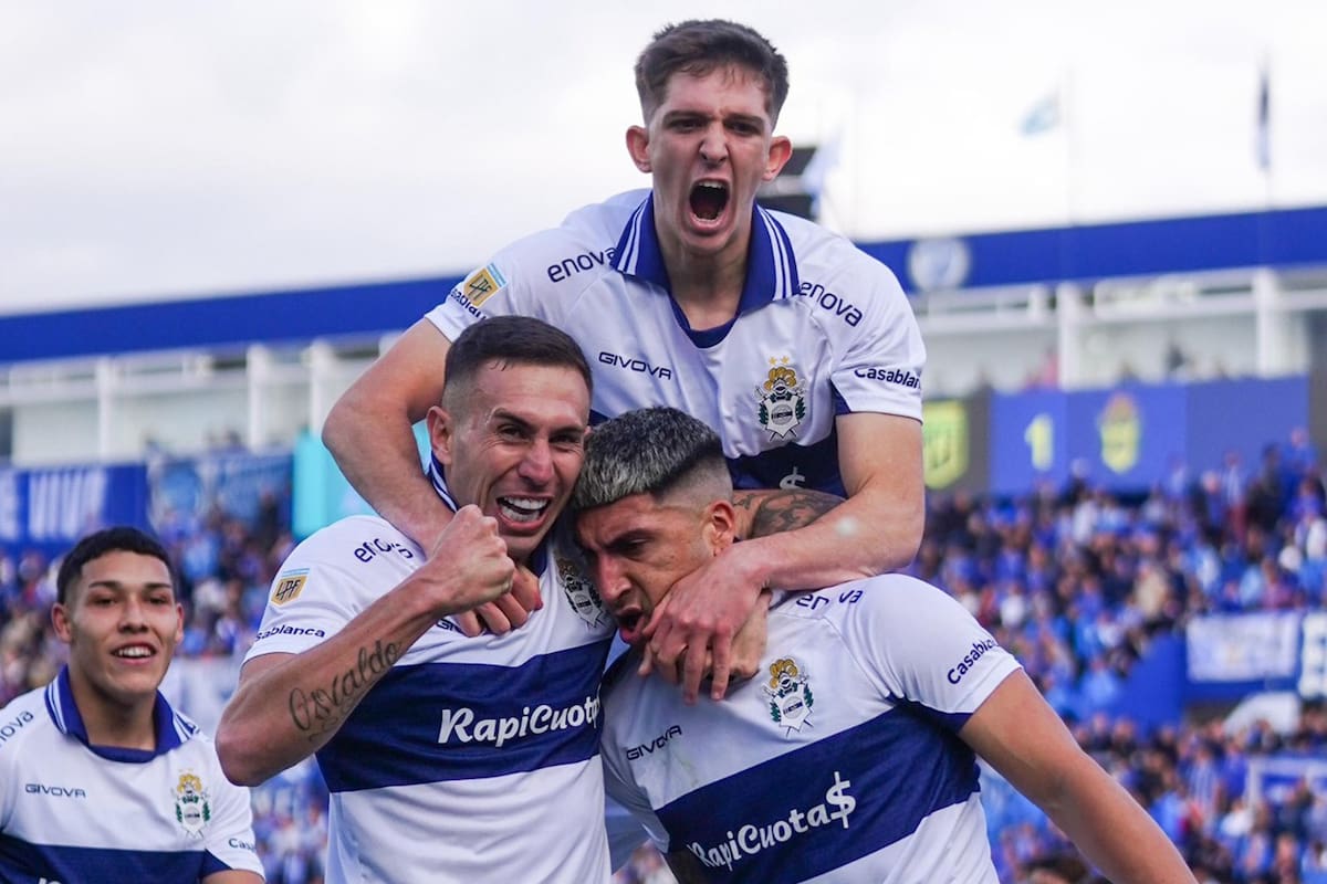 Marcelo Torres consiguió el gol del 1-0 y lo abrazan Norberto Briasco y Mateo Seoane; con dos goles en cinco minutos, Gimnasia venció a Godoy Cruz en Mendoza.