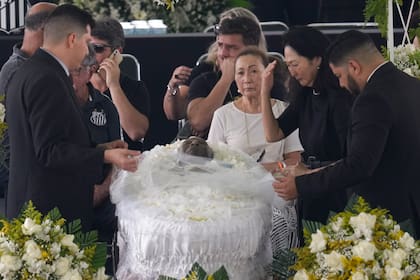 Marcia Aoki, the widow of Brazilian soccer great Pele, mourns over his body that lies in state at Vila Belmiro stadium during his wake in Santos, Brazil, Monday, Jan. 2, 2023. (AP Photo/Andre Penner)