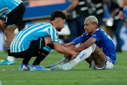 Marco Di Cesare, de Racing de Argentina, consuela a Matheus Pereira, de Cruzeiro de Breasil, tras la final de la Copa Sudamericana, el sábado 23 de noviembre de 2023 (AP Foto/Jorge Sáenz)